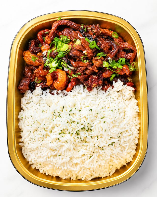 Black pepper beef with rice in a takeaway tray
